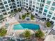 Aerial view of the community pool, hot tub, and sun deck surrounded by lush landscaping and modern architecture at 111 S Pineapple Ave # 918, Sarasota, FL 34236