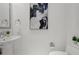 Stylish half-bathroom featuring pedestal sink, modern art, and white fixtures at 111 S Pineapple Ave # 918, Sarasota, FL 34236