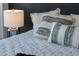 Closeup of king bed with an assortment of decorative pillows and chrome bedside lamp at 111 S Pineapple Ave # 918, Sarasota, FL 34236