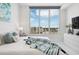 Bright bedroom featuring a large window with city views, modern decor, and a comfortable bed with stylish pillows and a throw blanket at 111 S Pineapple Ave # 918, Sarasota, FL 34236