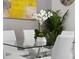 Dining table centerpiece with floral arrangement and decorative plants adding natural beauty to a contemporary dining room setting at 111 S Pineapple Ave # 918, Sarasota, FL 34236