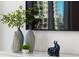 Close-up of a modern entertainment center with decorative vases, plants, and stylish art pieces, enhancing the room's aesthetic appeal at 111 S Pineapple Ave # 918, Sarasota, FL 34236