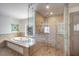 Bright bathroom features a soaking tub, glass enclosed shower, tile flooring, and a stained-glass window at 1111 Ritz Carlton Dr # 1704, Sarasota, FL 34236