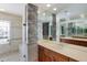 Bright bathroom with a large mirror, double vanity, walk-in shower, and patterned wallpaper at 1111 Ritz Carlton Dr # 1704, Sarasota, FL 34236