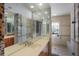 Bright bathroom featuring a large mirror, double vanity, and a walk-in shower with decorative glasswork at 1111 Ritz Carlton Dr # 1704, Sarasota, FL 34236