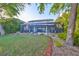 A backyard features a large grass area, a pool, a spa and an outdoor kitchen at 11408 Drifting Leaf Dr, Riverview, FL 33579