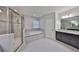 Spacious bathroom featuring double sinks, a walk-in shower, and a soaking tub at 11408 Drifting Leaf Dr, Riverview, FL 33579