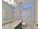 Cozy bathroom featuring a granite vanity top, shower with palm tree curtain, and a bright mirror at 11408 Drifting Leaf Dr, Riverview, FL 33579