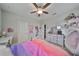 This bedroom boasts a ceiling fan, a dresser with mirror, and decorative shelving for added flair at 11408 Drifting Leaf Dr, Riverview, FL 33579