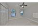 Carpeted bedroom with two windows, ceiling fan and double closet at 11408 Drifting Leaf Dr, Riverview, FL 33579