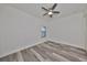 Simple bedroom featuring wood-look floors, neutral walls, and a ceiling fan for added comfort at 11408 Drifting Leaf Dr, Riverview, FL 33579