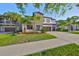 Charming two-story home with stone accents, manicured lawn, palm trees, and a spacious driveway at 11408 Drifting Leaf Dr, Riverview, FL 33579