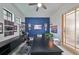 Bright office space with modern desk, blue accent wall, and ample natural light at 11408 Drifting Leaf Dr, Riverview, FL 33579