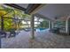 A covered patio features a pool, a spa, a dining set and two lounge chairs at 11408 Drifting Leaf Dr, Riverview, FL 33579