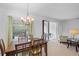 The dining room includes a chandelier, large window, and access to the outdoor patio area with tile flooring throughout at 12225 Whisper Lake Dr, Bradenton, FL 34211