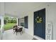 Cozy front porch area with seating, white railing, dark shutters and a navy front door at 12225 Whisper Lake Dr, Bradenton, FL 34211