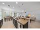 Open-concept kitchen features granite countertops, pendant lighting, and stainless steel appliances with views into the living spaces at 12225 Whisper Lake Dr, Bradenton, FL 34211