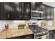 Close up shot of stainless stove and granite counters in stylish dark kitchen at 12225 Whisper Lake Dr, Bradenton, FL 34211