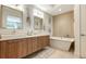 Elegant bathroom featuring double sinks, a soaking tub, and stylish wood vanity at 129 Taft Dr # W102, Sarasota, FL 34236