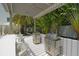 An outdoor kitchen features two stainless steel grills and covered seating area surrounded by lush tropical foliage at 129 Taft Dr # W102, Sarasota, FL 34236