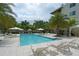Resort-style pool area with lounge chairs, umbrellas, and lush landscaping at 129 Taft Dr # W102, Sarasota, FL 34236