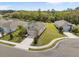 Aerial view of a well-maintained home with lush landscaping, a manicured lawn, and a tranquil water view at 13718 Woodbridge Ter, Lakewood Ranch, FL 34211