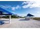 Beachside cabanas on white sand with nearby condos and easy access to sparkling blue gulf waters at 1580 Harbor Cay Ln, Longboat Key, FL 34228