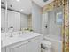 Elegant bathroom with marble countertops, wallpaper, and floral shower curtain at 2161 Gulf Of Mexico Dr # 3, Longboat Key, FL 34228