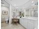 Bright bathroom with a white vanity, decorative mirror, and a tiled floor at 2161 Gulf Of Mexico Dr # 3, Longboat Key, FL 34228