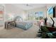 Bright bedroom with plush carpet, ceiling fan, and sunny window with tropical views at 2161 Gulf Of Mexico Dr # 3, Longboat Key, FL 34228