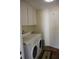 Practical laundry room with washer, dryer, storage cabinets, and a utility sink for added convenience at 2320 Tanglewood Dr, Sarasota, FL 34239