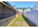 Narrow grassy backyard with white fence and screened in porch at 2564 Wood St, Sarasota, FL 34237
