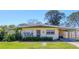 Charming single-story home with a well-maintained lawn and a covered carport on a sunny day at 2564 Wood St, Sarasota, FL 34237