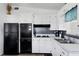 Functional kitchen featuring classic white cabinets, sleek black appliances, and an efficient layout for cooking at 2564 Wood St, Sarasota, FL 34237