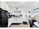 Efficient kitchen with white cabinetry, black appliances, and a cozy dining area for casual meals at 2564 Wood St, Sarasota, FL 34237