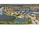 Aerial view of community with residences surrounding a lake, featuring a community center with pool and tennis courts at 2927 Bravura Lake Dr, Sarasota, FL 34240