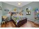 Bright bedroom with a sunflower-themed bedspread, window view, and wood floors at 2927 Bravura Lake Dr, Sarasota, FL 34240