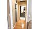 A hallway with wood floors leading to a bathroom with cabinets, vanity and a closet providing ample storage space at 3246 Maiden Ln, Sarasota, FL 34231