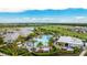 Aerial view of a luxurious community pool, clubhouse, and golf course with lush landscaping and beautiful views at 3639 Santa Caterina Blvd, Lakewood Ranch, FL 34211