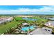 Aerial view of a community pool surrounded by lush landscaping and a picturesque golf course with scenic ponds at 3639 Santa Caterina Blvd, Lakewood Ranch, FL 34211