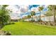 Well-manicured backyard featuring lush green lawn, mature landscaping, and a view of the screened in lanai at 3639 Santa Caterina Blvd, Lakewood Ranch, FL 34211