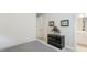 Bright bedroom featuring a dark dresser with decorative accents and a doorway leading to an en-suite bathroom at 3639 Santa Caterina Blvd, Lakewood Ranch, FL 34211