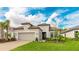 Charming one-story home with a neutral color scheme, attached garage, tile roof, manicured lawn, and verdant landscaping at 3639 Santa Caterina Blvd, Lakewood Ranch, FL 34211
