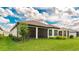 Rear exterior of home featuring a covered lanai, tile roof, lush lawn, and established landscaping at 3639 Santa Caterina Blvd, Lakewood Ranch, FL 34211