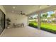 Covered lanai with ceiling fan, seating, and expansive views of the beautifully landscaped backyard at 3639 Santa Caterina Blvd, Lakewood Ranch, FL 34211