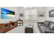 Relaxing living room featuring a large screen TV, comfortable couch, and plenty of natural light at 3639 Santa Caterina Blvd, Lakewood Ranch, FL 34211