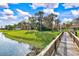 Scenic lake view with a wooden pier, green lawn, gazebo, and ducks near community buildings at 4005 Crockers Lake Blvd # 26, Sarasota, FL 34238