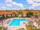 Aerial view of a beautiful outdoor pool area with lounge chairs, tables, and a nearby cabana at 4005 Crockers Lake Blvd # 26, Sarasota, FL 34238