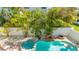 A tropical backyard features a pool, spa, and lounge chairs, with a small waterfall and lush tropical vegetation at 4101 4Th Ave, Holmes Beach, FL 34217