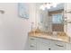 Bathroom with a vanity, granite countertop, glass shelves, and patterned wall art at 4101 4Th Ave, Holmes Beach, FL 34217